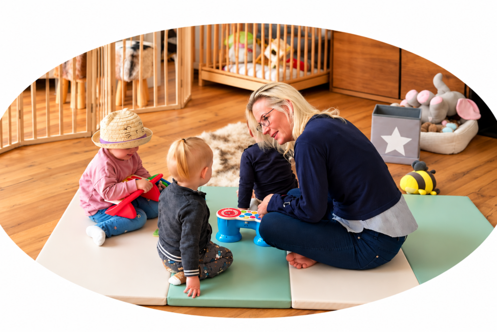 Martina spielt mit drei Kindern auf der Spielmatte im Wichtelgarten.